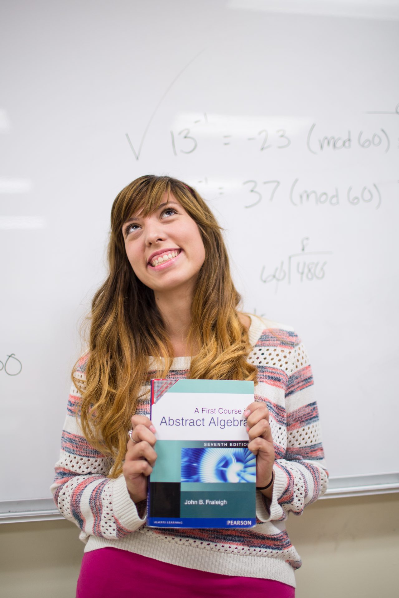 Student holding up algebra book