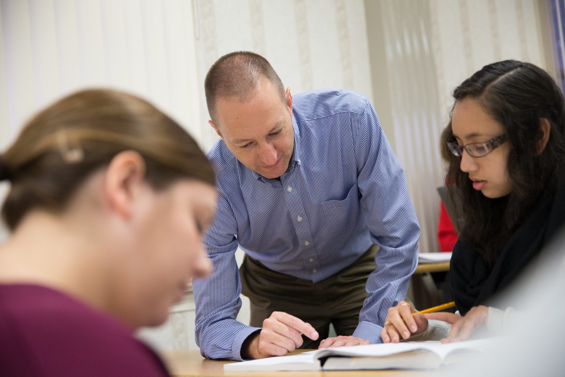 Professor showing a student something in their book