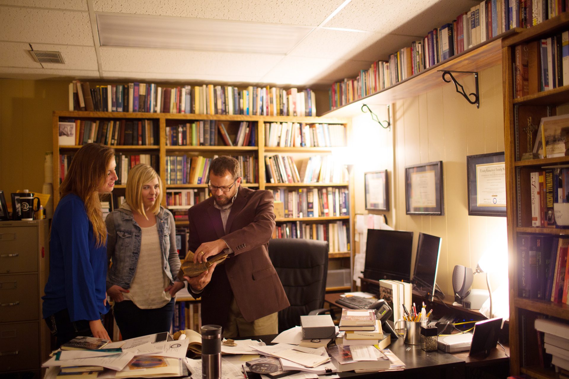 Students with history professor in his office