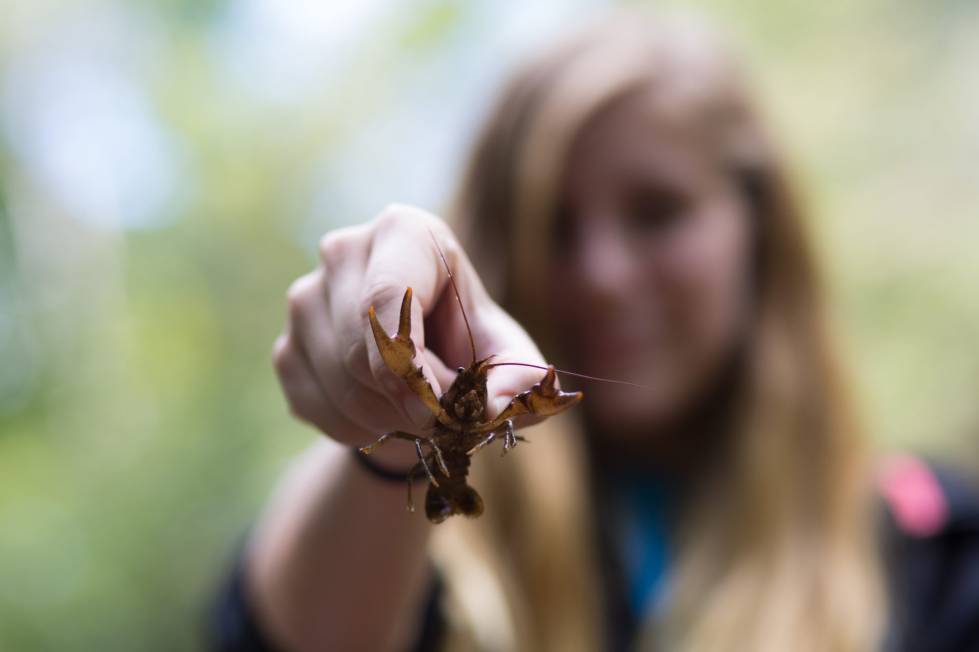 student holding a crawdad