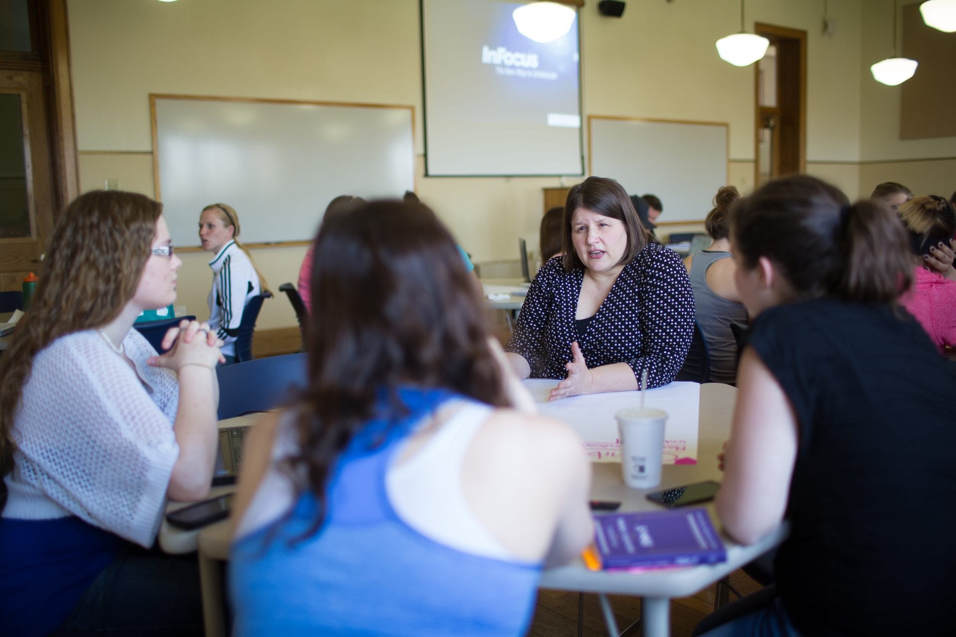 Lisa Wooley teaching students at table